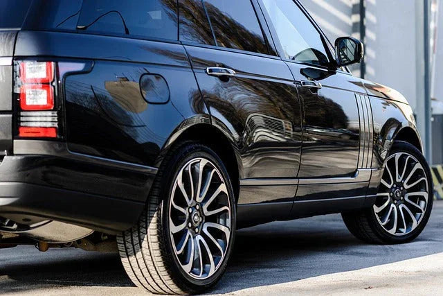 Black luxury SUV parked outdoors with shiny alloy wheels and glossy paint finish