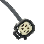 Close-up of a black automotive electrical connector plug with four metal pins on a white background