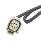 Close-up of a gray automotive electrical connector with three pins and attached black wire