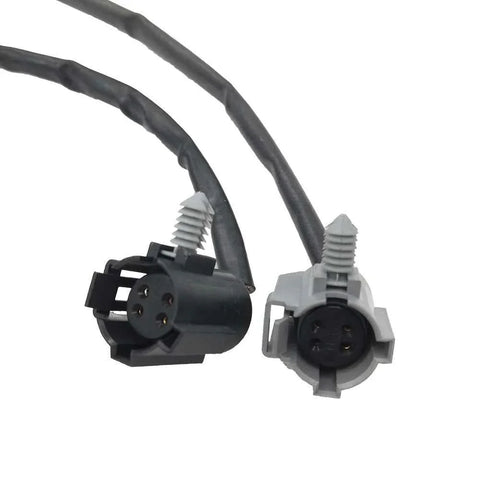 Close-up of black and gray 4-pin automotive electrical connectors with attached wiring harnesses