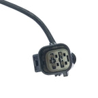 Close-up of a black automotive electrical connector plug with four metal pins and attached wire