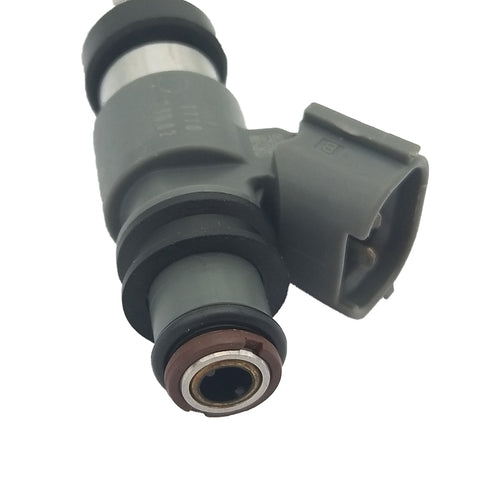 Close-up of a gray automotive fuel injector with rubber seals and electrical connector