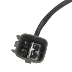 Close-up of a black automotive electrical connector with four metal pins and attached cable