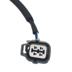 Close-up of a black automotive electrical connector with wiring against white background