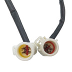 Close-up of two white automotive electrical connectors with black cables, showing metal pins inside
