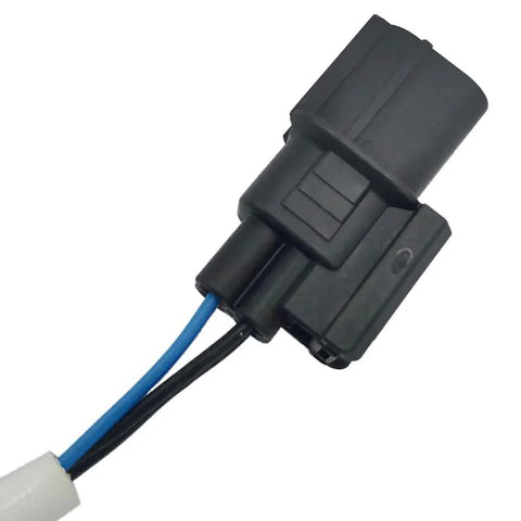 Close-up of black automotive electrical connector with blue and black wires on white background
