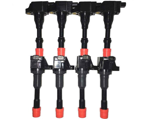 Set of four black automotive ignition coils with red caps on a white background